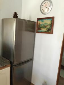 y cocina con nevera y reloj en la pared. en Casa Rural Anzo, en Gáldar