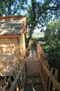 a wooden staircase leading up to a building with trees at Nuits perchées à Laroque in Saint-Antoine-de-Breuilh