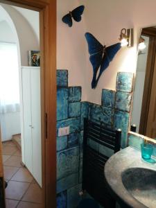a bathroom with butterflies hanging on the wall at Villa Fonte Tartaruga Trevignano Romano in Trevignano Romano