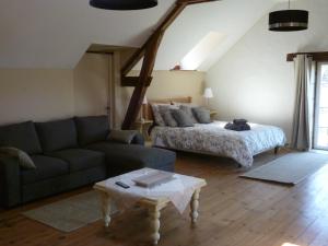 a living room with a couch and a bed at Le Moulin de Cors in Oulches