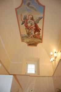 un plafond orné d'une peinture d'ange. dans l'établissement Casa del Drago, à Sulzano