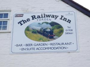 a sign for the railway inn on the side of a building at The Railway Inn in Forden