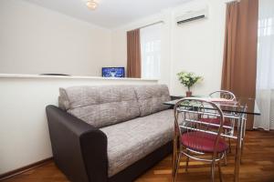 Cette chambre comprend un canapé, une table et des chaises. dans l'établissement Kvart-Hotel Estrella, à Moscou