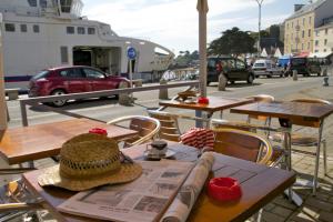 a hat sitting on a table with a newspaper on it at Hotel Atlantique in Le Palais