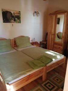 sypialnia z dużym łóżkiem z zieloną pościelą w obiekcie Vitis Vendégház w mieście Becsehely