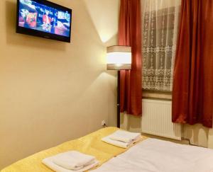 a room with a bed with a tv on the wall at Hotel i Restauracja Sara in Polanica-Zdrój +56 photos