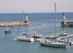 a group of boats in the water near a lighthouse at Hotel Atlantique in Le Palais