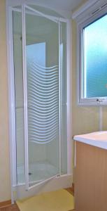 a glass shower in a bathroom with a window at Mobil-home St Georges in Saint-Georges-de-Didonne