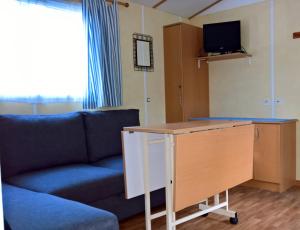 a living room with a couch and a desk at Mobil-home St Georges in Saint-Georges-de-Didonne