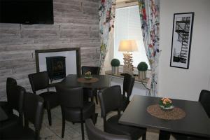 a dining room with two tables and chairs and a fireplace at CarlstadCity H Boutique Hotell in Karlstad