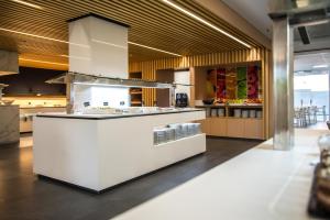 a kitchen with a white island in a restaurant at Hotel Prado II in Peñíscola