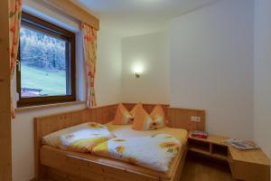 ein Schlafzimmer mit einem Holzbett und einem Fenster in der Unterkunft Haus Berthold in Sölden