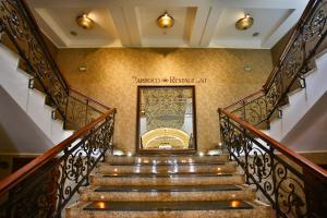 un escalier dans un bâtiment avec un panneau sur le mur dans l'établissement Hotel Select, à Iaşi