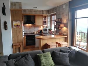 a living room with a couch and a kitchen at Lujoso duplex en Port del Comte in La Coma i la Pedra