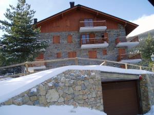 a building with a garage in the snow at Lujoso duplex en Port del Comte in La Coma i la Pedra