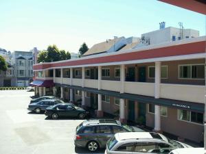 a parking lot with cars parked in front of a building at Town House Motel in San Francisco