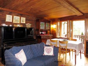 a living room with a couch and a table and a piano at Chalet Martina in Macugnaga