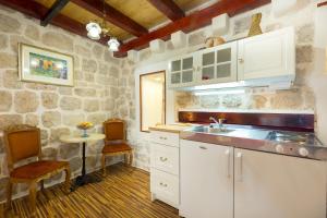una cucina con armadi bianchi e lavandino di Juliette's Palace Studios a Dubrovnik