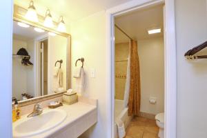 a bathroom with a sink and a toilet and a mirror at La Fiesta Ocean Inn & Suites in Saint Augustine Beach