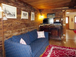 a living room with a blue couch and a tv at Chalet Martina in Macugnaga