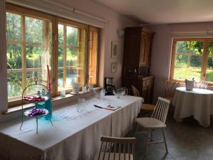 ein Esszimmer mit zwei Tischen und zwei Fenstern in der Unterkunft River Villa, 20 min by train to Old Town, big yard in Lagedi