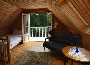 Zimmer mit Sofa, Bett und Tisch in der Unterkunft River Villa, 20 min by train to Old Town, big yard in Lagedi
