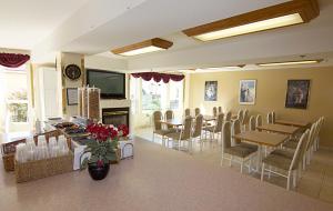 a dining room with tables and chairs and a fireplace at Western Budget Motel Bonnyville in Bonnyville