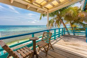 un portico con due sedie e l'oceano di Ranguana Caye Cabanas a Placencia