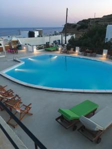 a large swimming pool with chairs and a table at Golden Star in Ios Chora