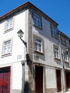 een wit gebouw met een straatlicht ervoor bij PWHC Miragaia Apartments in Porto