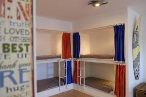 a room with three bunk beds in it with a mirror at Dezassete - Ericeira in Ericeira