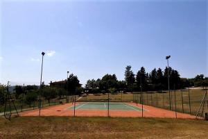 a tennis court in a park with lights on it at Agriturismo Comparone Casavecchia in Città di Castello