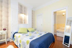 1 dormitorio con 1 cama con manta azul y amarilla en Apartamento frente al Guggenheim con wifi y parking privado gratis, en Bilbao