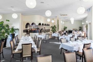 a dining room with white tables and chairs at BreakFree Queanbeyan in Queanbeyan