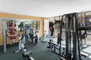 un gimnasio con varias cintas de correr y bicicletas estáticas en Garden City Hotel, Best Western Signature Collection en Canberra