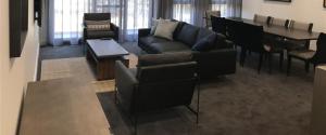 ein Wohnzimmer mit einer Couch und Stühlen und einem Tisch in der Unterkunft Knightsbridge Canberra in Canberra + 37 Fotos