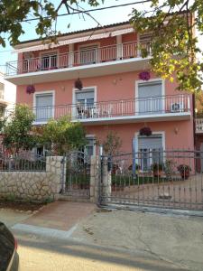 a pink building with a fence in front of it at Villa Mirjana in Dramalj