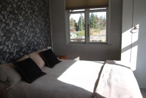 a bedroom with a bed and a window at Judge Rock Exclusive Vineyard Cottage Accommodation in Alexandra