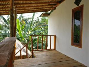 a wooden walkway leading to the balcony of a house at Eco Mawun Homestay in Kuta Lombok