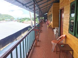 a balcony of a building with chairs and tables at Scenery Guest House in Phi Phi Islands