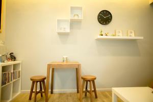 una habitación con dos taburetes y un reloj en la pared en The Suvarnabhumi Apartment en Bang Kew Yai