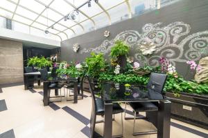 un comedor con mesas y plantas en la pared en Chiayi King Hotel, en Chiayi