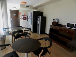 a room with two tables and chairs and a refrigerator at Hotel Río Hortega in Valladolid