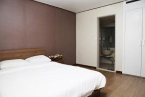 una camera da letto con un letto bianco e un bagno di Ilsung Resort Sulak a Goseong
