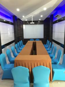 a conference room with a long table and blue chairs at OS Hotel Airport Batam in Batam Center