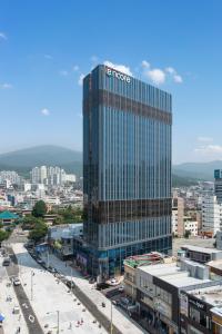 duży budynek z znakiem na boku w obiekcie Ramada Encore by Wyndham Busan Haeundae w Pusanie