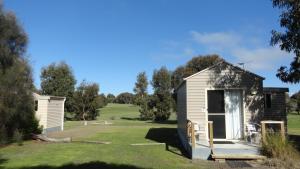een kleine schuur met een veranda in een tuin bij Kangaroo Island Cabins in Kingscote