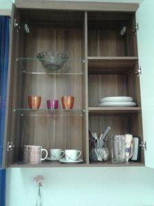 a wooden shelf with cups and dishes on it at Apartment im Zentrum Steyr, 2 Betten BESTROOMS eU in Steyr