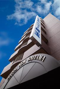 a tall building with a sign on top of it at Hotel New Saitama in Saitama