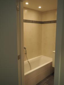 ein Bad mit einer Badewanne und einem WC in der Unterkunft Appartement "FD" in Koksijde